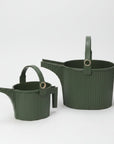 Two green watering cans with handles on a white background